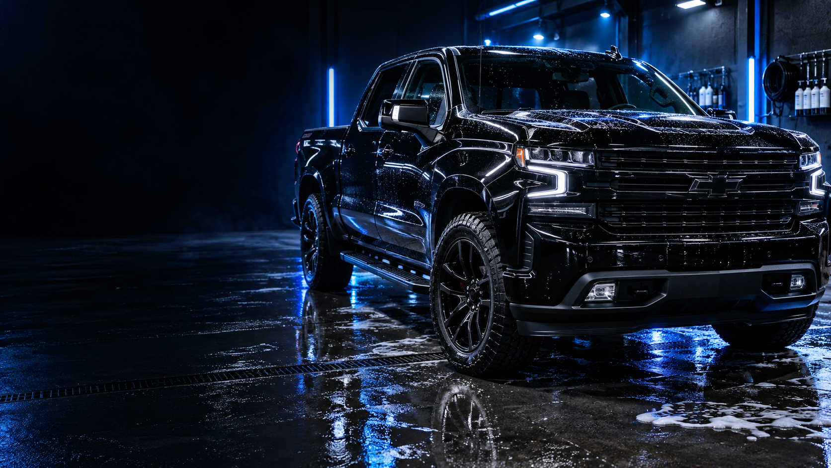 Freshly detailed black pickup truck under blue studio lights